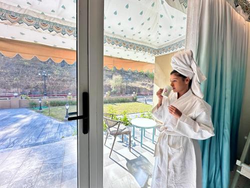 a woman in a robe talking on a cell phone at Regenta Resort Bhuj by Royal Orchid Hotels Limited in Bhuj