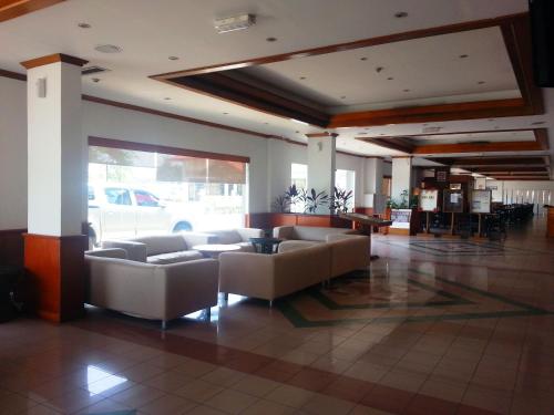 eine Lobby mit Sofas und Tischen in einem Gebäude in der Unterkunft Sanbay Hotel in Sandakan