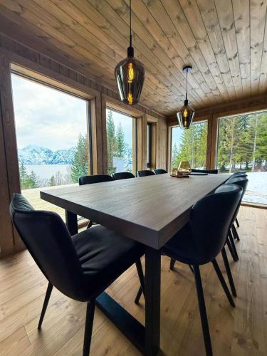 a dining room with a large wooden table and chairs at Lyngen Vista - Arctic Luxury in Hamnnes