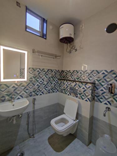 a bathroom with a toilet and a sink at Jazzy Beach Guest Rooms in Visakhapatnam