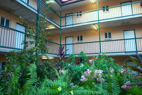 a building with a bunch of plants in front of it at Alatai Holiday Apartments in Darwin