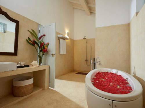 a bathroom with a bath tub filled with red material at Pooja Kanda in Habaraduwa Central