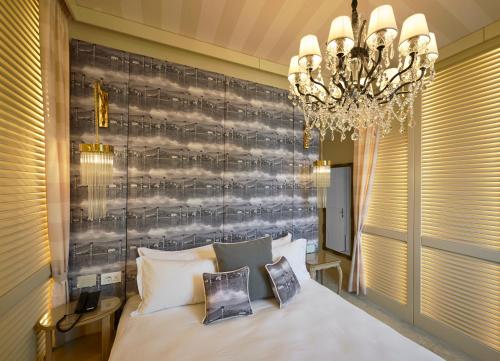 a bedroom with a large bed and a chandelier at Nuvole Garden Hotel in Brunate