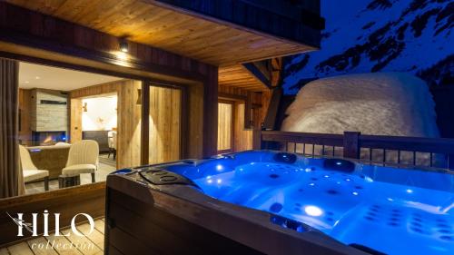 - une grande baignoire bleue dans une chambre avec un lit dans l'établissement Hilo Suite Val d Isere Gelinotte avec Jacuzzi, à Val dʼIsère