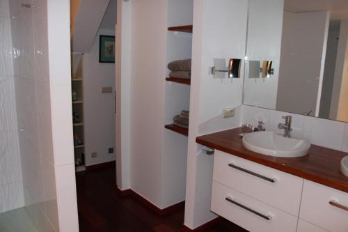 Baño blanco con lavabo y espejo en Chambre d'hôtes CitaBel'Air, en Namur