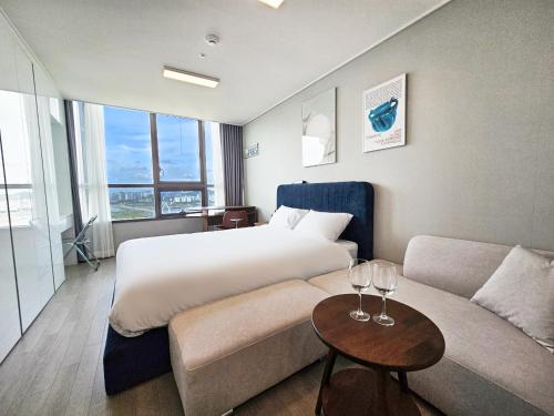 a hotel room with a bed and a couch at UH FLAT The SONGDO in Incheon