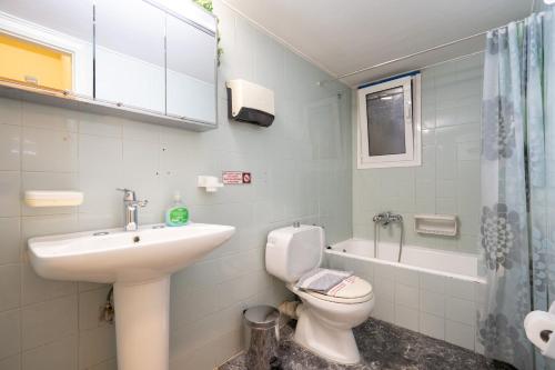 a white bathroom with a sink and a toilet at Syntagma square 1 bedrm 4 persons apartment by MPS in Athens