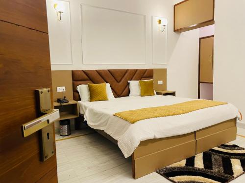 a bedroom with a large bed with yellow pillows at Hotel Dileep42 in Lucknow