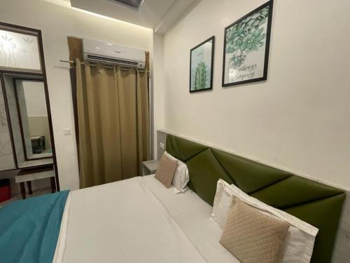 a bedroom with a bed with a green headboard at Hotel Dileep42 in Lucknow