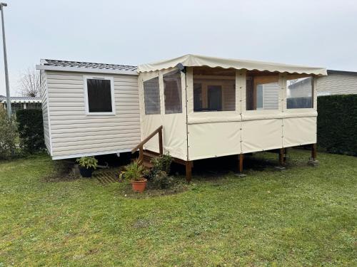 une maison blanche avec un toit sur une cour dans l'établissement Mobile home au calme et paisible, aux Mathes