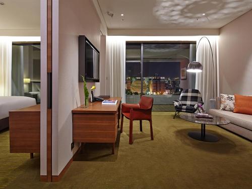 a hotel room with a bed and a living room at Eslite Hotel in Taipei