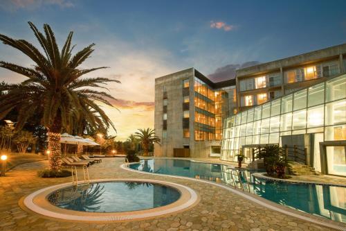 a hotel with a swimming pool in front of a building at Phoenix Island in Seogwipo