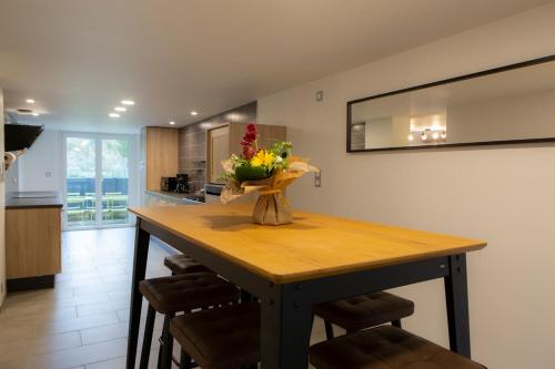 a kitchen with a table with a vase of flowers on it at Gîtes de l'Orée du Bois - Torpes in Torpes