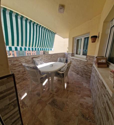 a patio with a table and chairs and windows at Castillo Apartament in Torremolinos