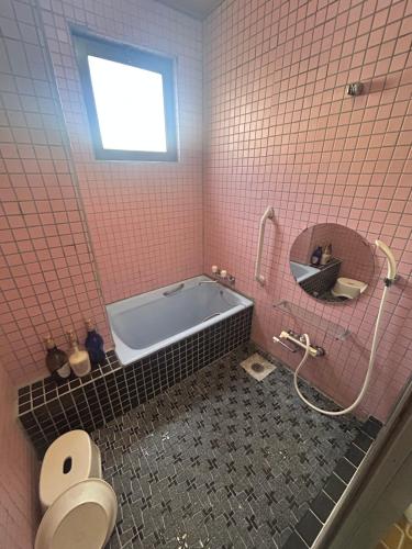 a bathroom with a tub and a toilet and a sink at Business Hotel Nakayama in Nagoya