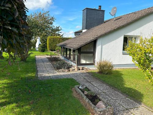 a house with a stone path leading to the front yard at Ferienhaus – Bergblick am Köterberg in Lügde