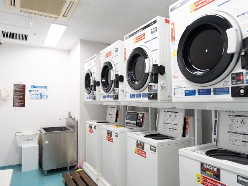 a row of washing machines in a laundry room at Hearton Hotel Kita Umeda in Osaka