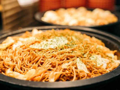 a pan filled with spaghetti with cheese and herbs at Hearton Hotel Kita Umeda in Osaka