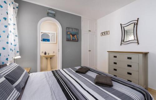 a small bedroom with a bed and a dresser at Villa Barry Swimming Pool, Amazing Sea Views, Bar in Tarajalejo