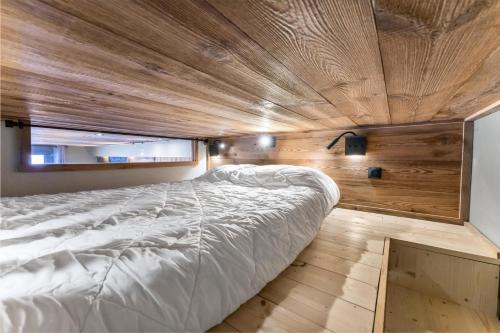 un grand lit dans une chambre avec un plafond en bois dans l'établissement Résidence Les Hauts De Preclaux - Appartement cocooning avec vue sur les pistes MAE-4551, aux Orres