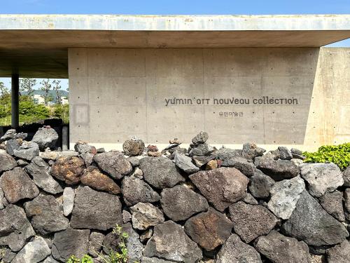 a wall of rocks in front of a building at Phoenix Island in Seogwipo