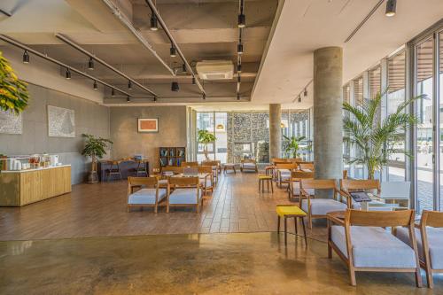 a restaurant with tables and chairs and windows at Phoenix Island in Seogwipo
