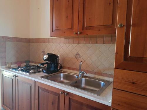 a kitchen with a stainless steel sink and a stove at Villette di Scopello - Casa Vacanze in Scopello
