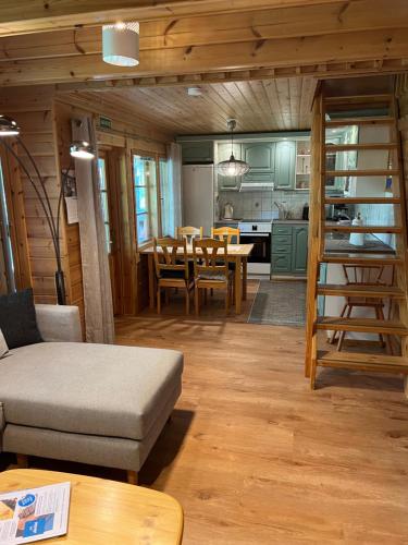 a living room and kitchen with a couch and a table at Vuokatin Aateli Kreivi in Vuokatti
