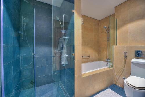 a bathroom with a glass shower with a toilet at Capital Suites Hotel Apartments in Abu Dhabi