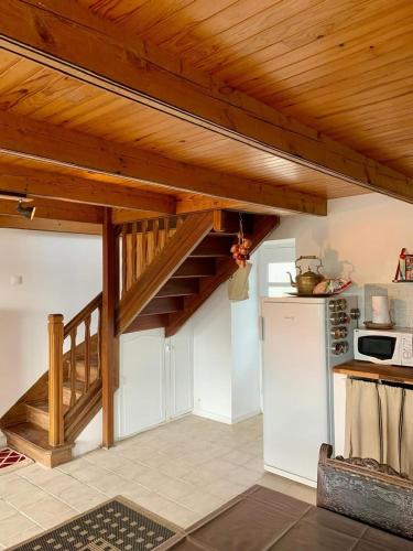 - une cuisine avec un escalier en bois et un réfrigérateur dans l'établissement Belle maison bretonne, à Plouguerneau