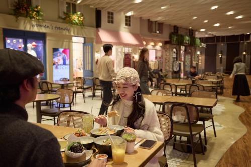 a woman sitting at a table eating food in a restaurant at Grand Hyatt Jeju in Jeju