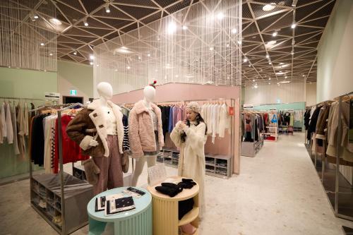 a woman is standing in a clothes store at Grand Hyatt Jeju in Jeju