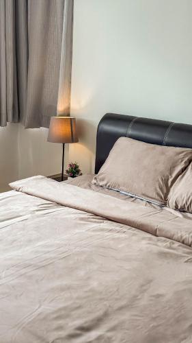 a bedroom with a bed with a lamp and a window at Comfy Sunset View Home with Swimming Pool & Netflix in Taiping
