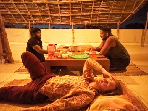 a group of three men sitting around a table at Healing Home And Hostel Auroville in Puducherry