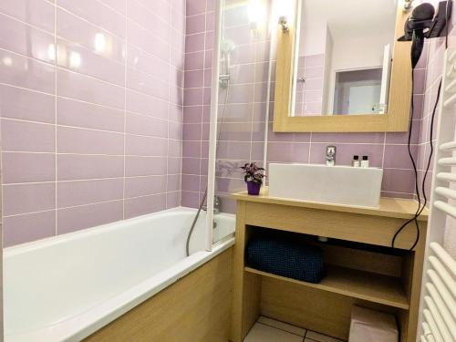 une salle de bain avec une baignoire et un lavabo dans l'établissement Le cocon des sables, à Moliets-et-Maa