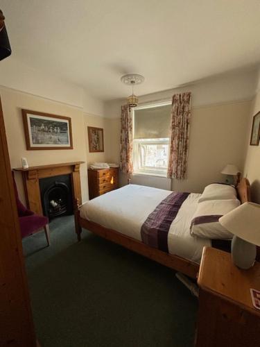 a bedroom with a bed and a fireplace and a window at The Seagulls 3 Bedroom House with Parking Weymouth in Weymouth