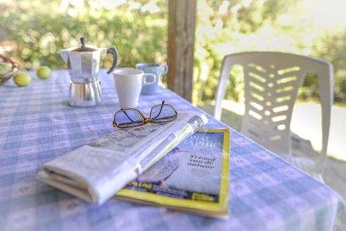 a table with a book and glasses on it at Villaggio Colombo NUOVA GESTIONE in Marina dʼAndora