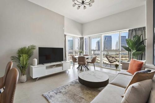 a living room with a television and a table with chairs at Silkhaus Al Reem island Modern 1BDR in Abu Dhabi