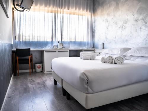 a bedroom with a large white bed and a sink at Hotel Valpolicella International in San Pietro in Cariano