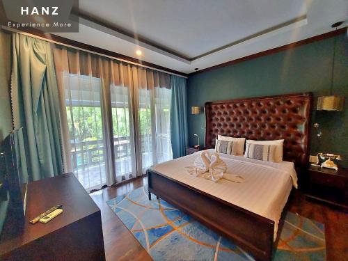 a bedroom with a large bed with a bow on it at Sunrise Hotel Luang Prabang Mekong river in Luang Prabang