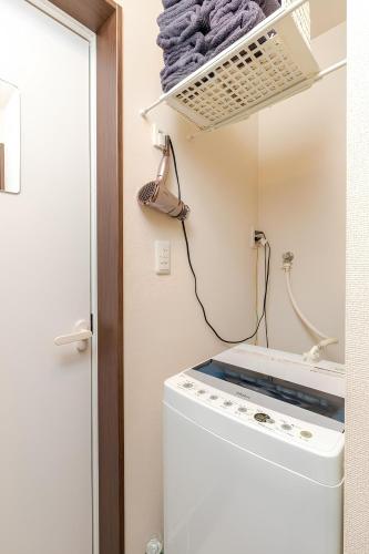 a washing machine in a bathroom with a mirror at en stay 005 in Osaka