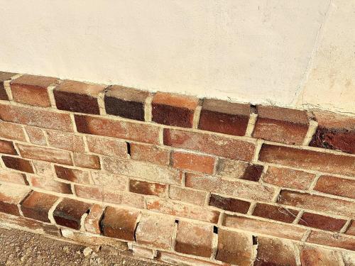 a red brick wall next to a street at 宿坊 三徳館 in Takasaki