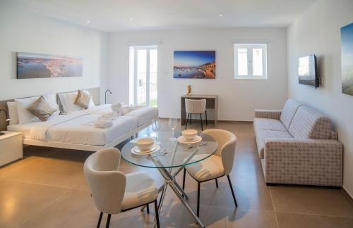 Una sala de estar con una cama, una mesa y sillas. en Orbis Boutique Studios by Holi, en Qormi