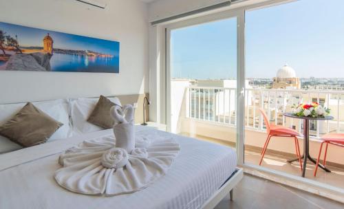 a bedroom with a white bed with a swan on it at Orbis Boutique Studios by Holi in Qormi