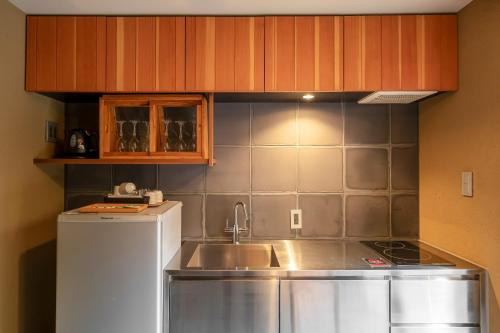 a small kitchen with a sink and a refrigerator at GOZAN HOTEL & SERVICED APARTMENT Higashiyama Sanjo in Kyoto