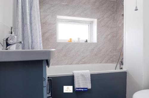a bathroom with a sink and a tub and a window at Centrally Located 3 Bedroom House By Trinity Stays Short Lets & Serviced Accommodation Cambridge in Cambridge