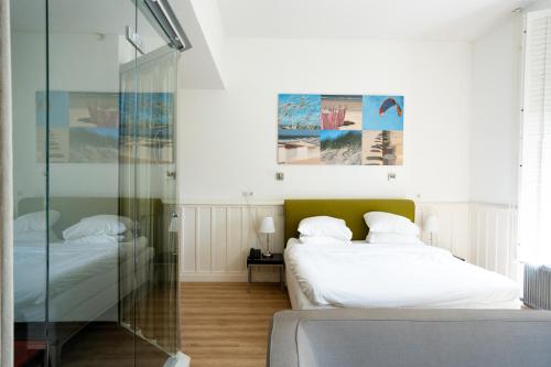 a bedroom with two beds and a glass wall at Hotel Villa Ruimzicht in Doetinchem