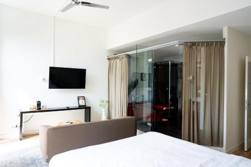 a bedroom with a bed and a sliding glass door at Hotel Villa Ruimzicht in Doetinchem