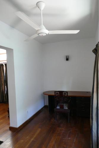 a dining room with a ceiling fan and a table at Embassy Suites in Colombo