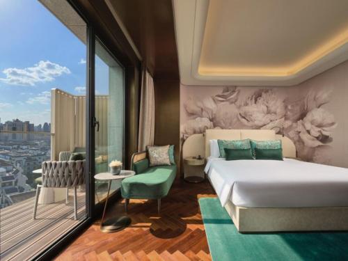 上海市にあるBlossom House Shanghai On The Bundのベッドとバルコニー付きのホテルルーム
